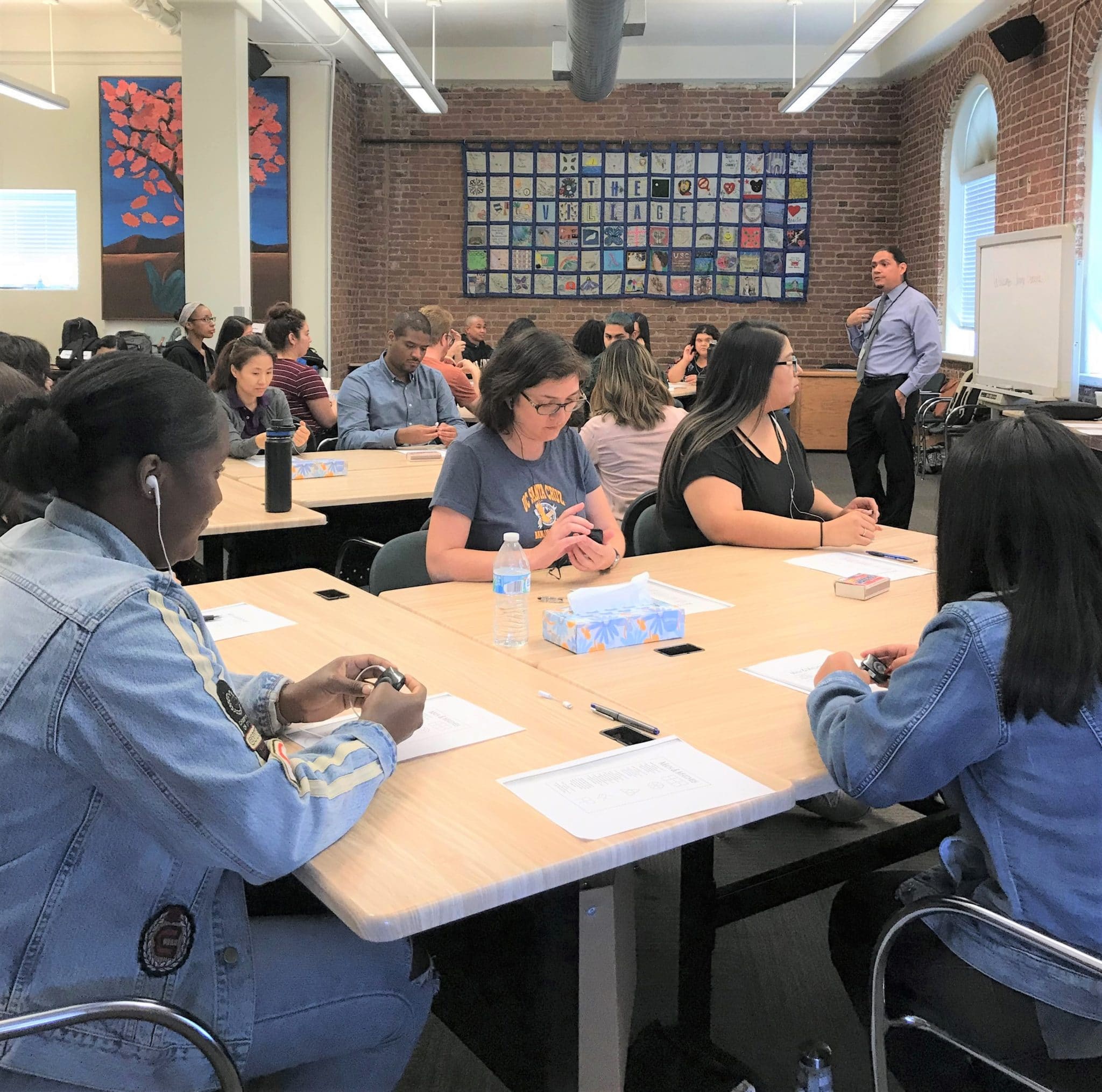 Adult students in a classroom listening to a male professor