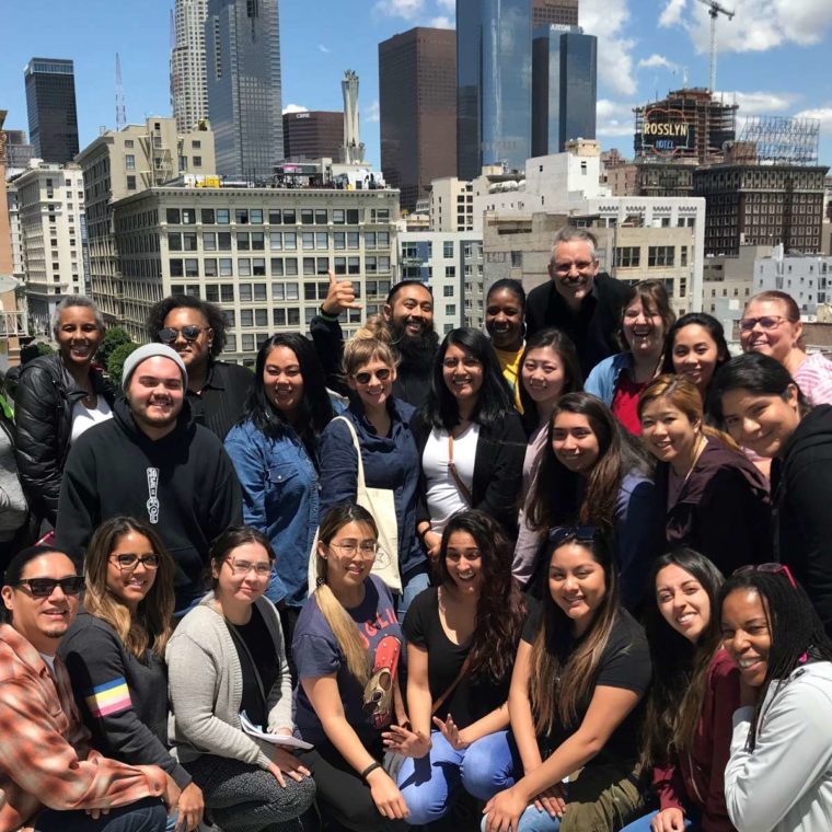 JumpStart Copy Group of students smiling at the camera with buildings behind them