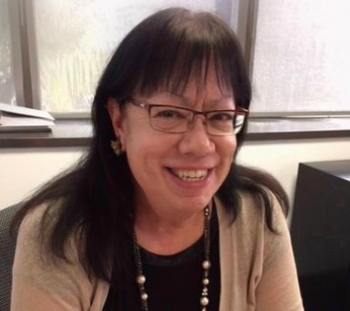 Woman in glasses smiling at camera