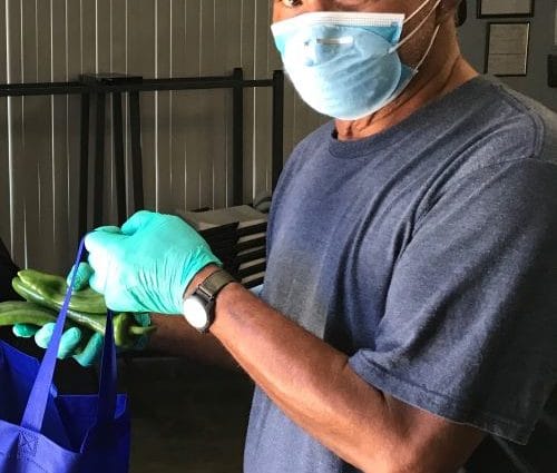 Main wearing mask putting food in a bag
