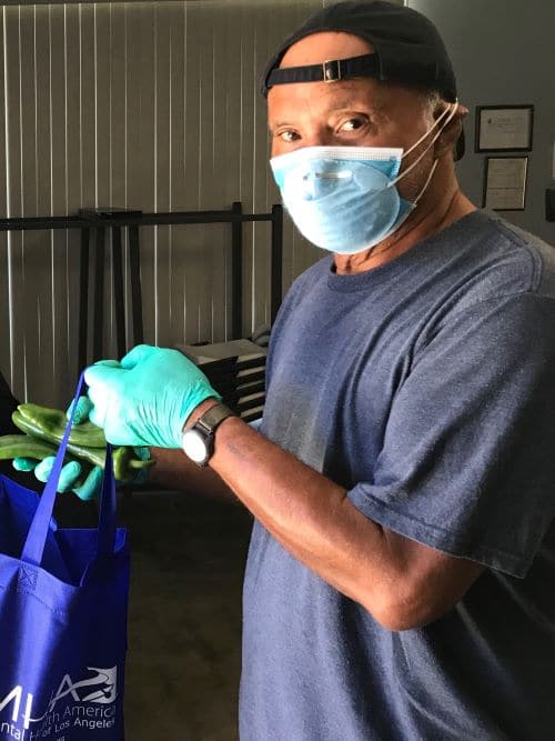 Main wearing mask putting food in a bag