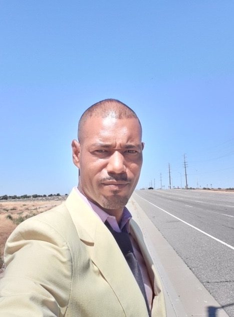 Man looking at the camera with highway behind him