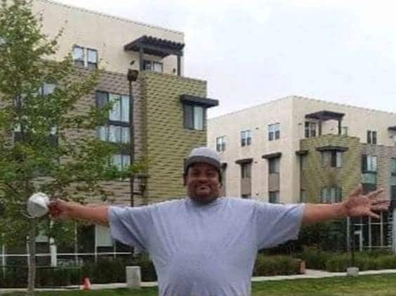 Man in front of buildings with arms wide open