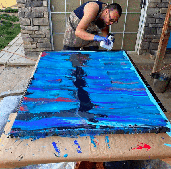Man painting abstract art outside