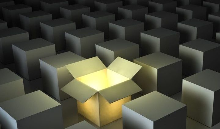 Stock photo of multiple closed boxes, with one box open and a light shining through it