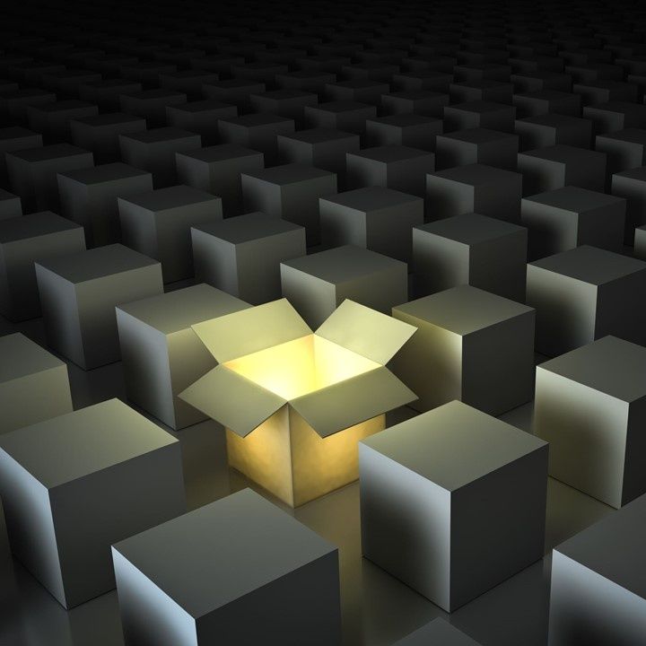 Stock photo of multiple closed boxes, with one box open and a light shining through it