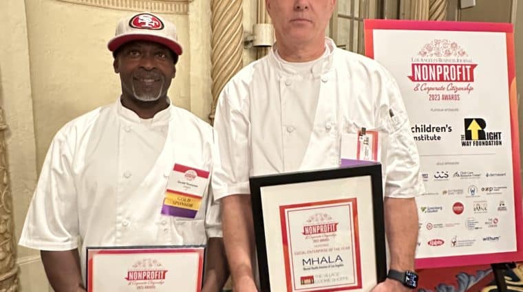Village Cookie Shoppe chefs holding framed Social Enterprise of the Year award.
