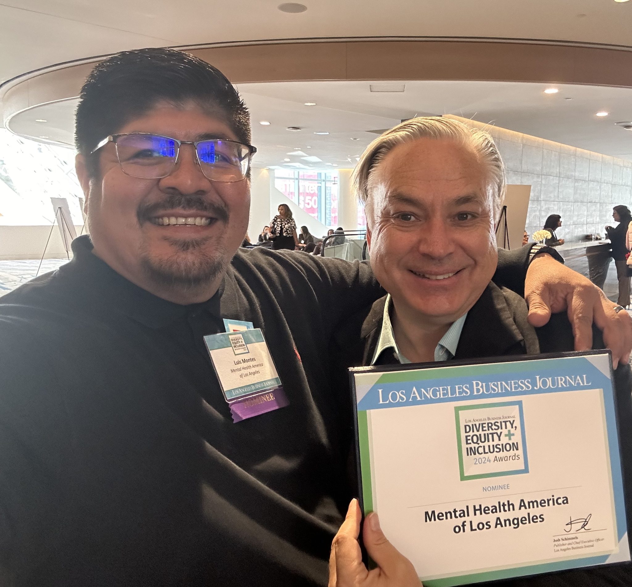MHALA chief service officers Luis Montes and Luther Richert hold MHALA's DEI certificate.