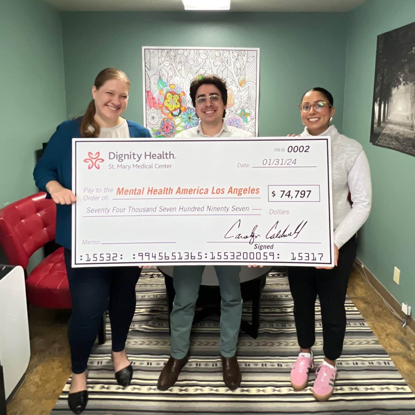 Three MHALA Wellness Center staff members holding a check from Dignity Health to continue HealthLink program.