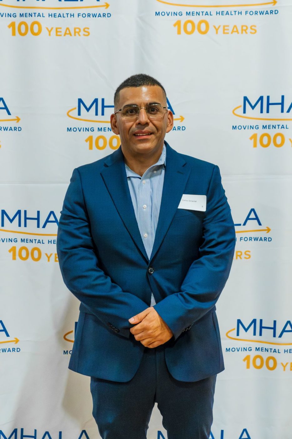 MHALA member Carlos S. in front of MHALA backdrop