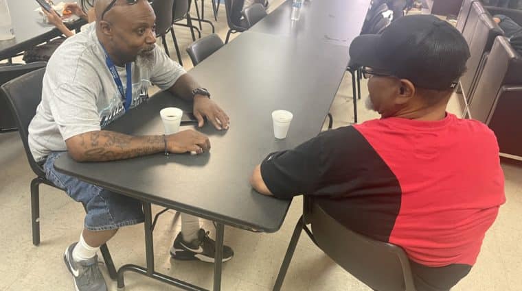 MHALA staff sits at table with MHALA member