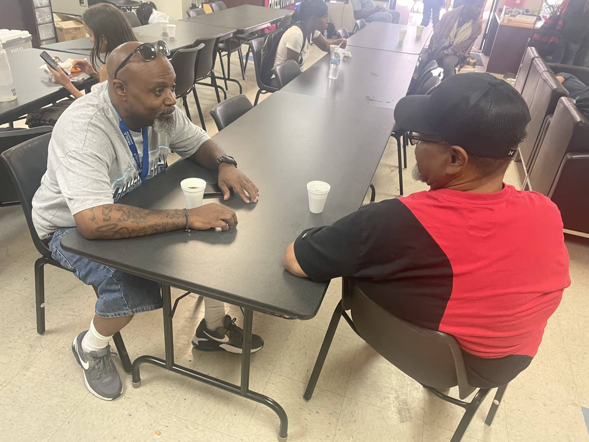 MHALA staff sits at table with MHALA member