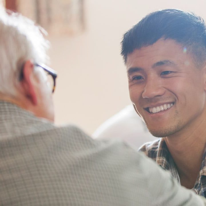 An older man talking to a younger man