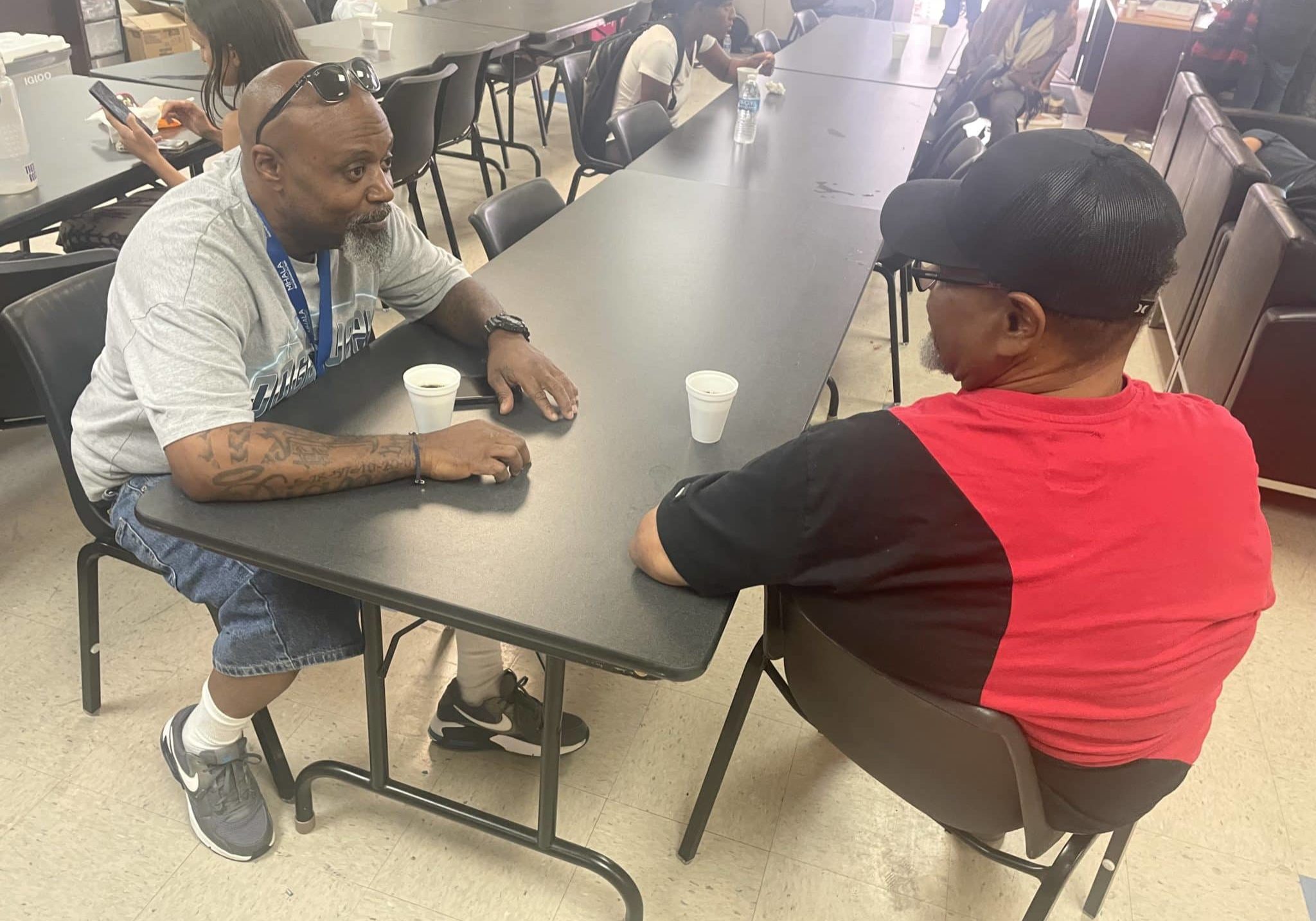 MHALA staff sits at table with MHALA member